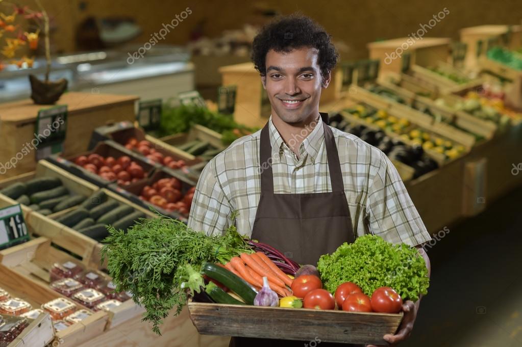 Grocery clerk working in produce aisle of supermarket store Stock Photo by  ©FreeProd 118793658