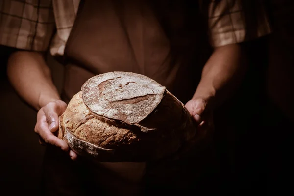 Baker man holding a round bread — Stock Photo, Image