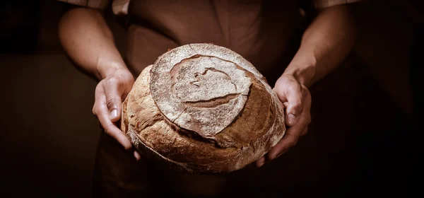 Baker man holding a round bread — Stock Photo, Image