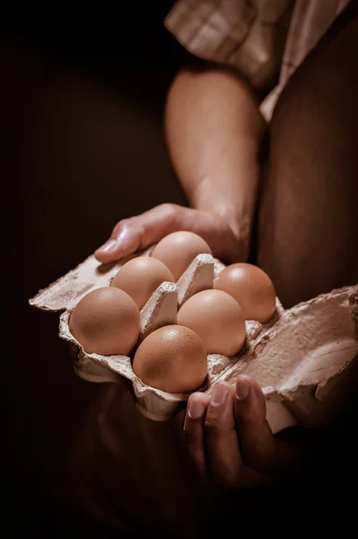 Bricka med ägg i bonden händer — Stockfoto
