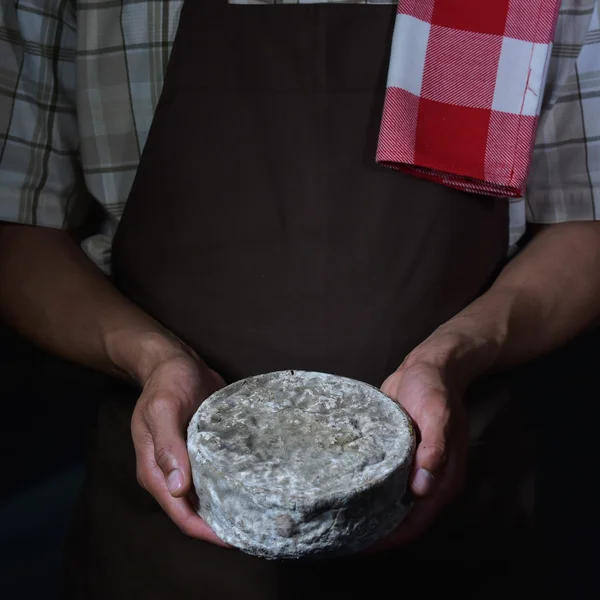 Franska tomme ost i händerna på en cheesemaker — Stockfoto