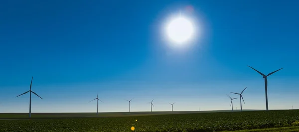 Větrné elektrárny pro výrobu elektrické energie na modré obloze — Stock fotografie