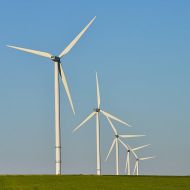 Yel değirmenleri mavi gökyüzü üzerinde elektrik enerjisi üretimi için