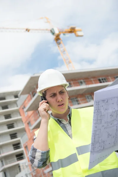 Gerente de construcción verificando proyecto de construcción en sitio —  Fotos de Stock