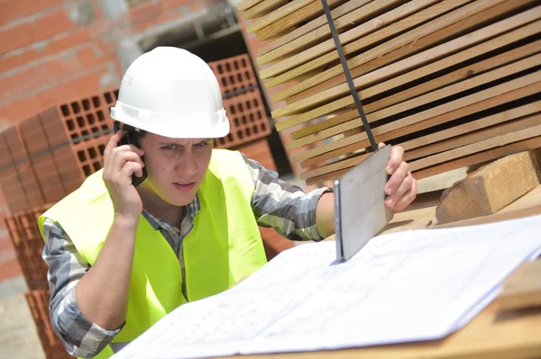 Contremaître utilisant talkie-walkie et tablette numérique sur le chantier de construction — Photo