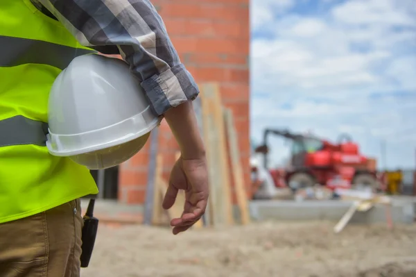 Trabajador sosteniendo un casco con fondo de obra . —  Fotos de Stock