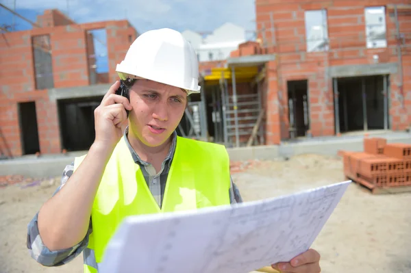 Gerente de construcción verificando proyecto de construcción en sitio —  Fotos de Stock