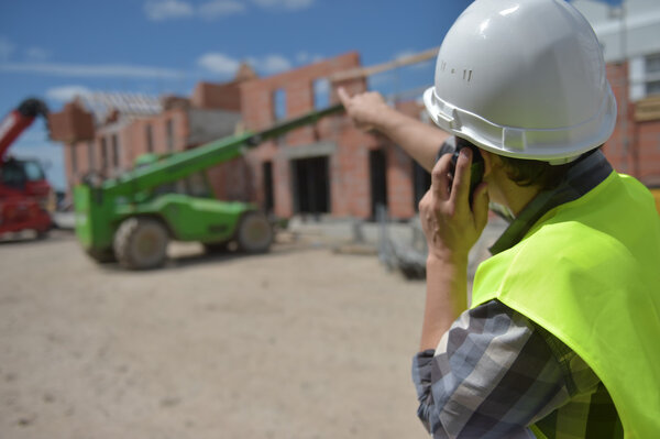 Foreman using walkie-talkie on construction site