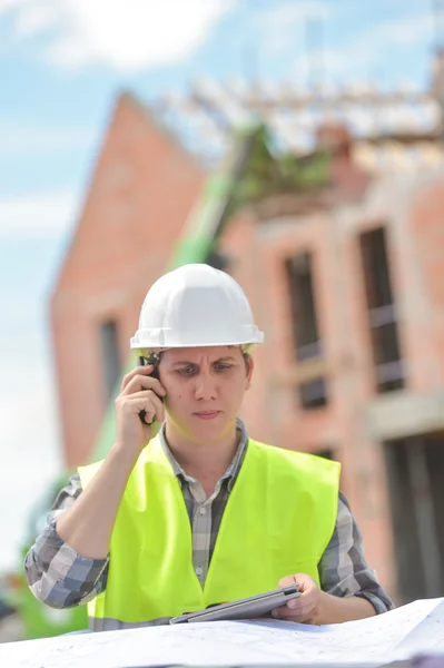 Foreman caminando usando walkie-talkie en el sitio de construcción —  Fotos de Stock