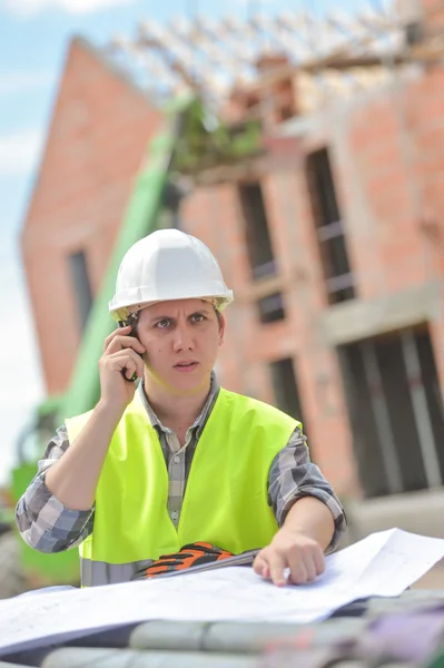 Foreman caminando usando walkie-talkie en el sitio de construcción —  Fotos de Stock