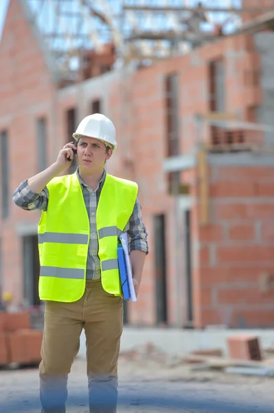 Majster chodzenie przy użyciu walkie-talkie na placu budowy — Zdjęcie stockowe