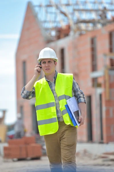 Foreman caminando usando walkie-talkie en el sitio de construcción —  Fotos de Stock