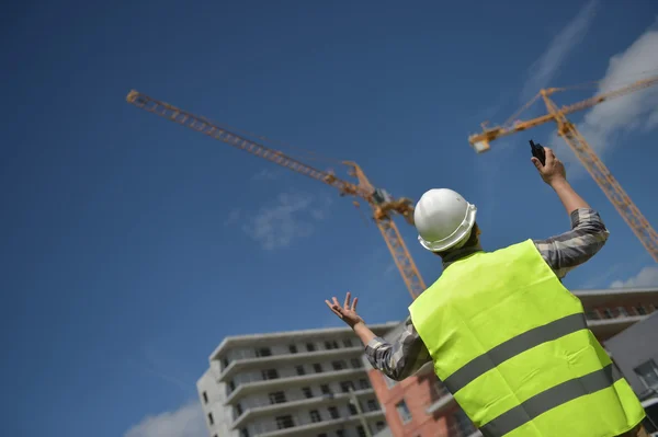 Foreman using walkie-talkie on construction site — Stock Photo, Image