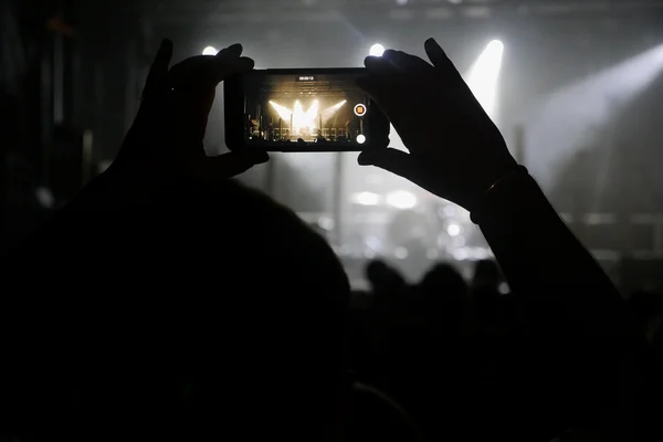 Silhouette delle mani registrazione video al concerto di musica — Foto Stock