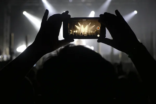 Silhouette delle mani registrazione video al concerto di musica — Foto Stock