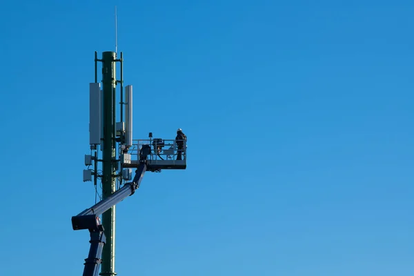 Torre de telecomunicaciones con transmisores 4G, 5G, Trabajador en estación base celular — Foto de Stock