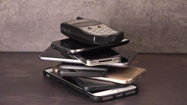 灰色の背景に新しい携帯電話に古い電話をタイムラプス ストック映像