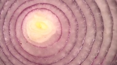 Dilimlenmiş kırmızı soğan halkaları dönüyor, yakın plan sağlıklı gıda arka planının zengin vitaminli sebzeli üst görüntüsü