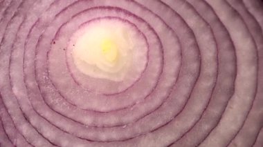 Dilimlenmiş kırmızı soğan halkaları dönüyor, yakın plan sağlıklı gıda arka planının zengin vitaminli sebzeli üst görüntüsü