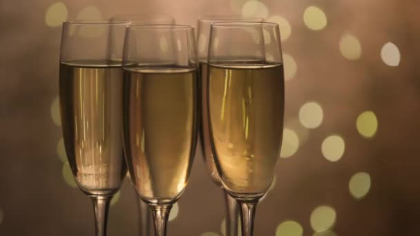 휴일에 눈 깜빡 할 정도로 배경을 덮은 샴페인 잔, 탁상 위에서 회전하는 잔, 반짝 이는 와인, 축하 파티, 파티 — 비디오