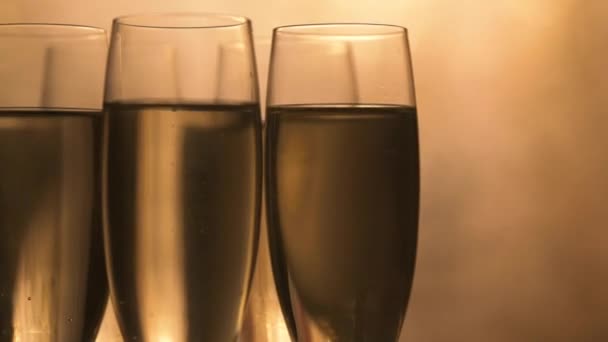 Kieliszki szampana nad wakacyjnym bokeh migające tło, obracające się na gramofonie, kieliszki z winem musującym, uroczystość, impreza — Wideo stockowe