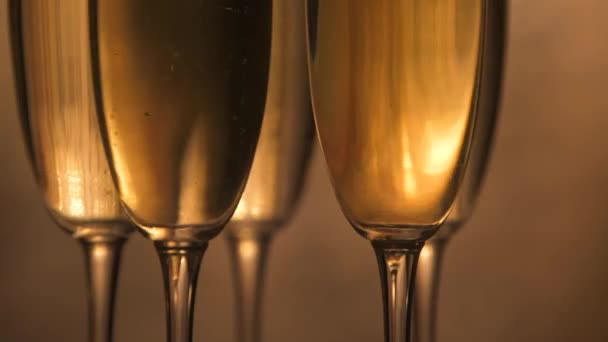 香槟酒杯盖在节日酒壶的背景上闪烁，在转盘上旋转，酒杯上有闪闪发光的葡萄酒，庆祝会，派对 — 图库视频影像