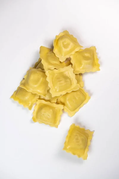 Chutné syrové ravioli s moukou a špenátem na bílém pozadí, proces tvorby italských ravioli — Stock fotografie