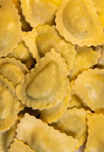 Chutné syrové ravioli s moukou a špenátem na bílém pozadí, proces tvorby italských ravioli — Stock fotografie