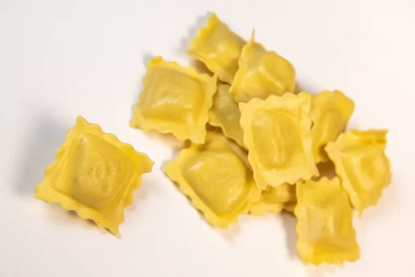 Chutné syrové ravioli s moukou a špenátem na bílém pozadí, proces tvorby italských ravioli — Stock fotografie