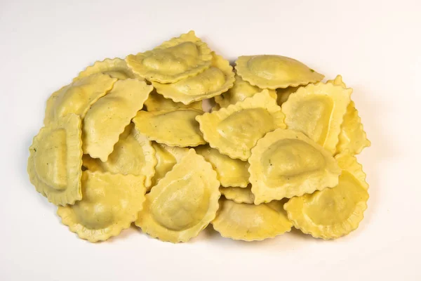 Sabrosos ravioles crudos con harina y espinacas sobre fondo blanco, proceso de elaboración de ravioles italianos —  Fotos de Stock