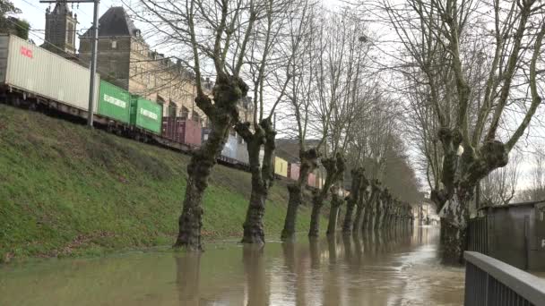 Sokakları su basmış bir köyden bir yük treni geçiyor. — Stok video