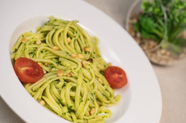 Tahta masada peynirli ve domatesli ıspanaklı spagetti.