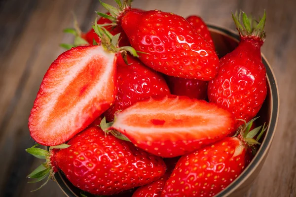 Frische Erdbeeren in einer Schüssel auf Holztisch mit niedriger Schlüsselszene — Stockfoto
