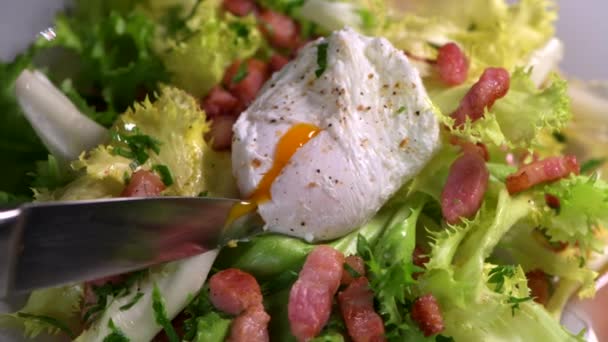 Ricetta uovo in camicia tagliato con un coltello, pancetta e insalata — Video Stock