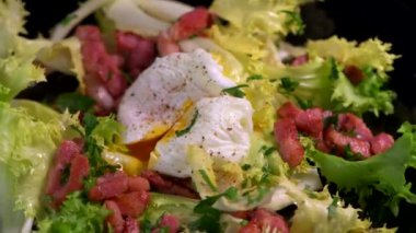 Haşlanmış yumurta tarifi. Bıçak, pastırma ve salata ile kesilmiş. 