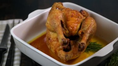 Beyaz tabakta kızarmış tavuk, siyah ahşap arka planda.