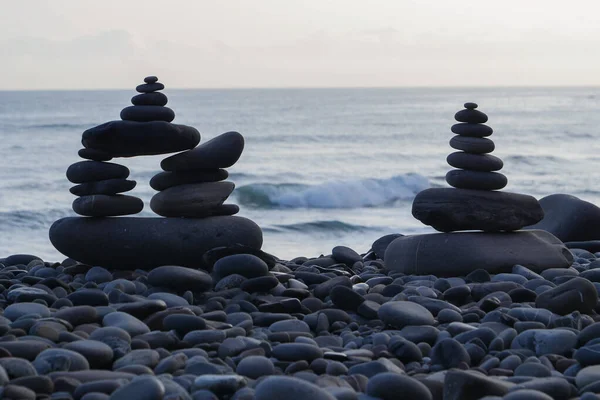 Stone piles made along a beach and the sea in the background