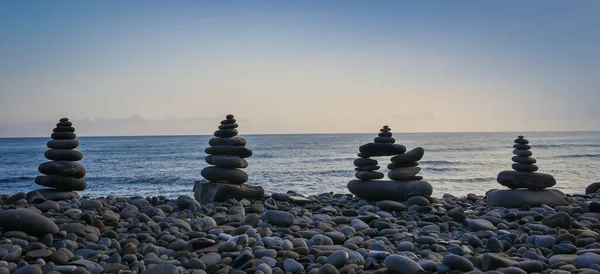 Stone piles made along a beach and the sea in the background