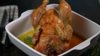 Beyaz tabakta kızarmış tavuk, siyah ahşap arka planda.