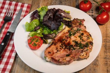 Izgara domuz pirzolası, akçaağaç şurubu ve taze kişniş sosu maydanoz, sarımsak ve salata..