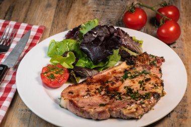 Izgara domuz pirzolası, akçaağaç şurubu ve taze kişniş sosu maydanoz, sarımsak ve salata..