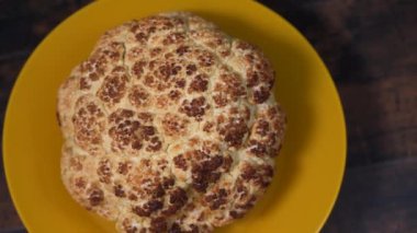 Sarı bir tabakta kavrulmuş karnabahar dönüyor.