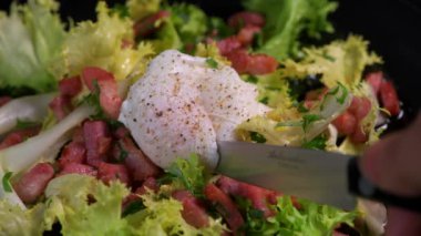 Haşlanmış yumurta tarifi. Bıçak, pastırma ve salata ile kesilmiş. 