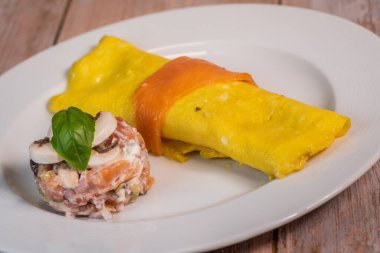 Somon ve domatesli omlet. Tabakta servis ediliyor. Geleneksel Norveç yemeği.