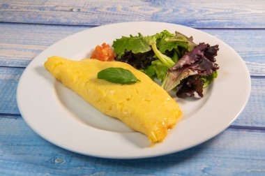 Somon ve otlu omlet. Tabakta servis ediliyor. Geleneksel Norveç yemeği.