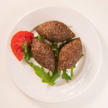 Lübnan restoranında büyük yuvarlak tabakta geleneksel kebbe ve pide ekmeği