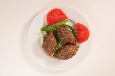 Lübnan restoranında büyük yuvarlak tabakta geleneksel kebbe ve pide ekmeği