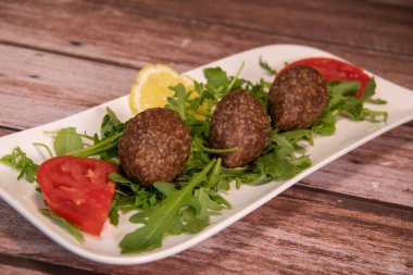 Lübnan restoranında büyük yuvarlak tabakta geleneksel kebbe ve pide ekmeği