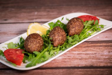 Lübnan restoranında büyük yuvarlak tabakta geleneksel kebbe ve pide ekmeği