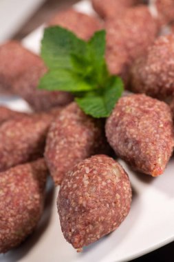 Lübnan restoranında büyük yuvarlak tabakta geleneksel kebbe ve pide ekmeği